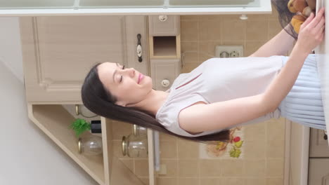 a woman stacks fruit in the kitchen the concept of vegetarianism eco bags for storing fruit a woman stacks fruit in the kitchen the concept of vegetarianism eco bags for storing fruit