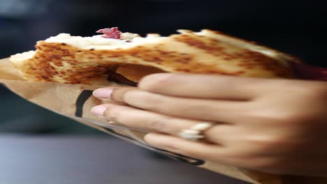 hand holding a turkish simit with meat