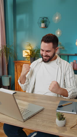 hombre de negocios trabajando en una computadora portátil netbook conmocionado por la victoria repentina celebrar la victoria buenas noticias de carrera