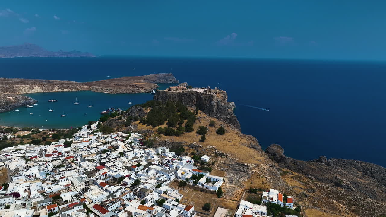Establishing drone shot approaching the Lindos fortress, in sunny Rhodes, Greece