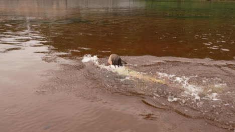 niña chapoteando y nadando en un río en cámara lenta