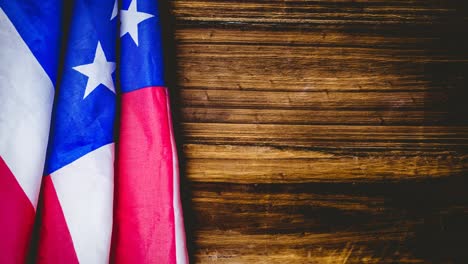 animation of american flag lying on wooden table