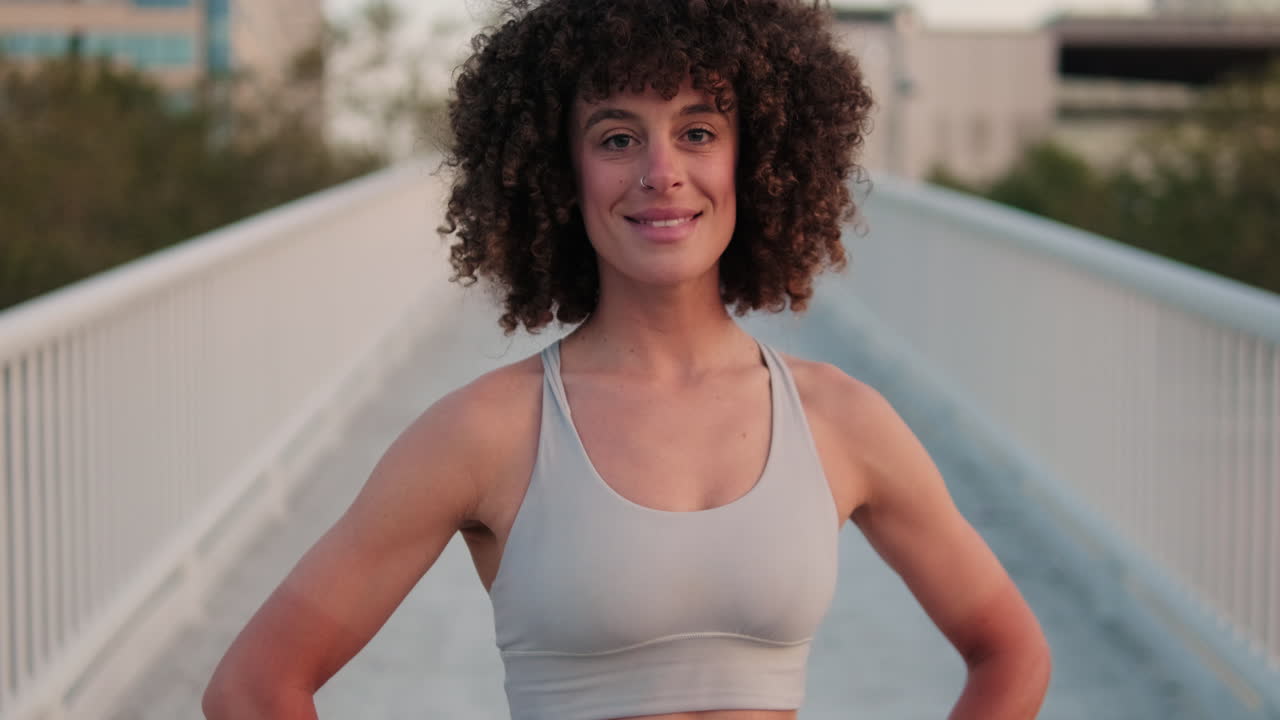 Happy Fit Woman Smiles on a City Bridge