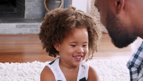 young black girl playing instrument with dad in sitting room