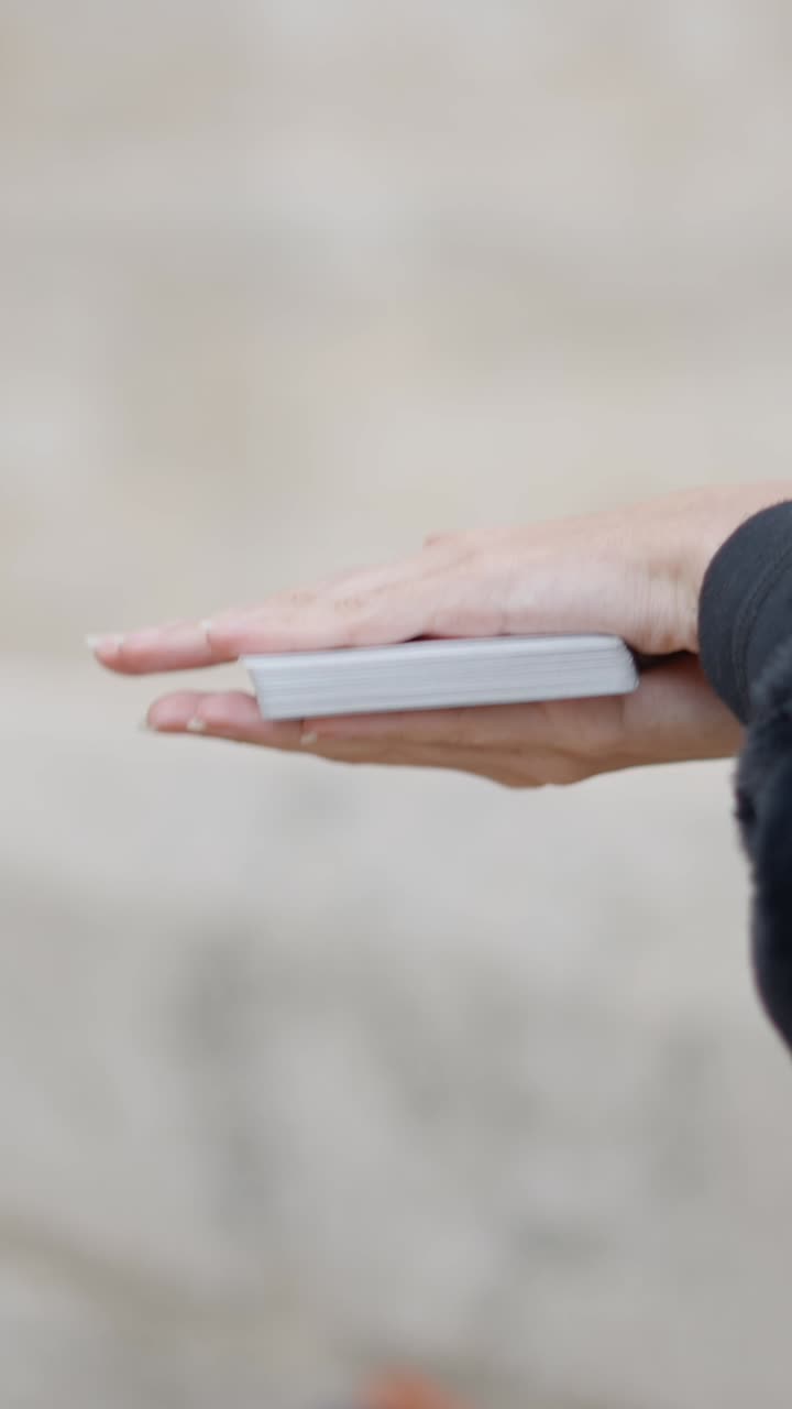 Hands interacting with a deck of playing cards