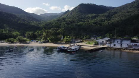 Aerial-view-around-boats,-anchored-at-a-beach-in-Ilha-Grande,-sunny-Brazil---low,-orbit,-drone-shot