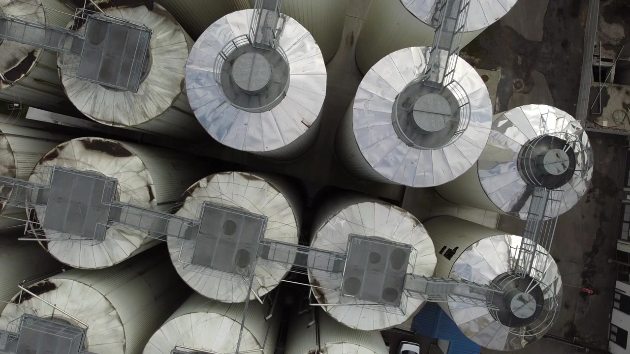 Aerial view of a drone flying over the beer production plant, several rows of tanks.