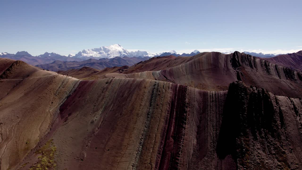 paisaje montañoso escarpado con características geológicas únicas, con picos que se extienden en la distancia bajo un cielo azul brillante.