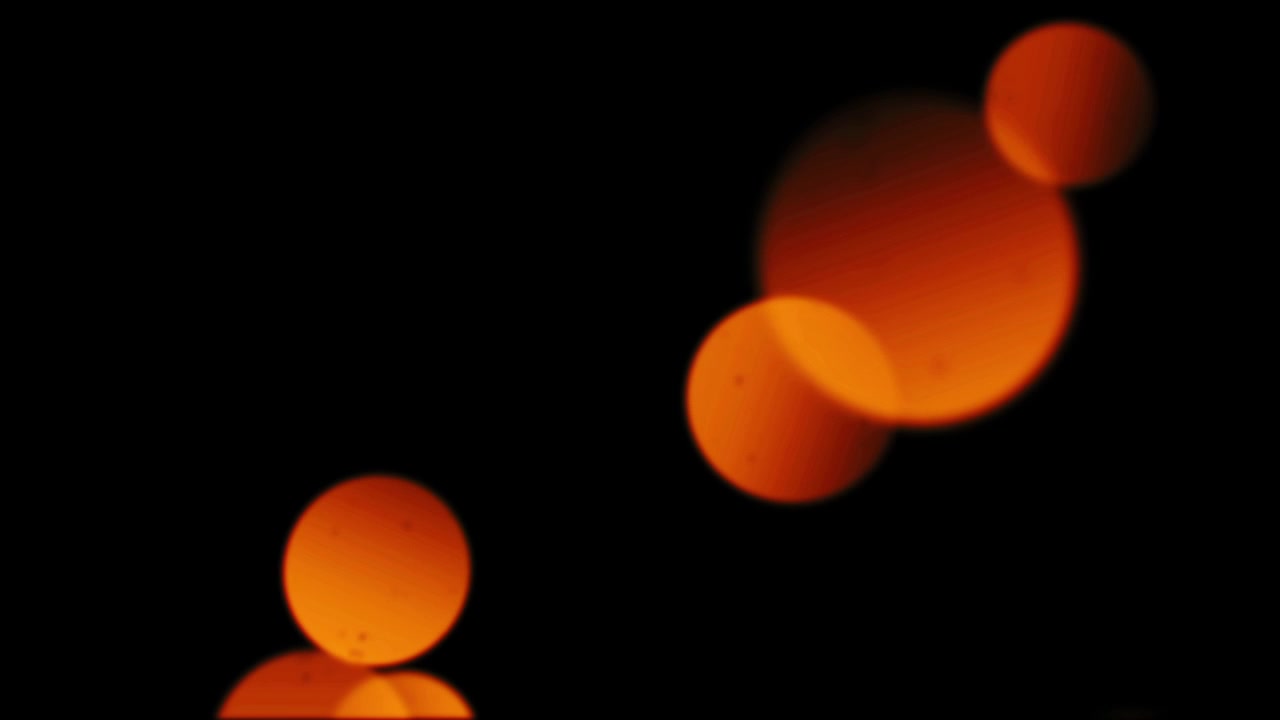 Abstrakte orangefarbene Bokeh-Lichter, die auf schwarzem Hintergrund ein- und ausblenden