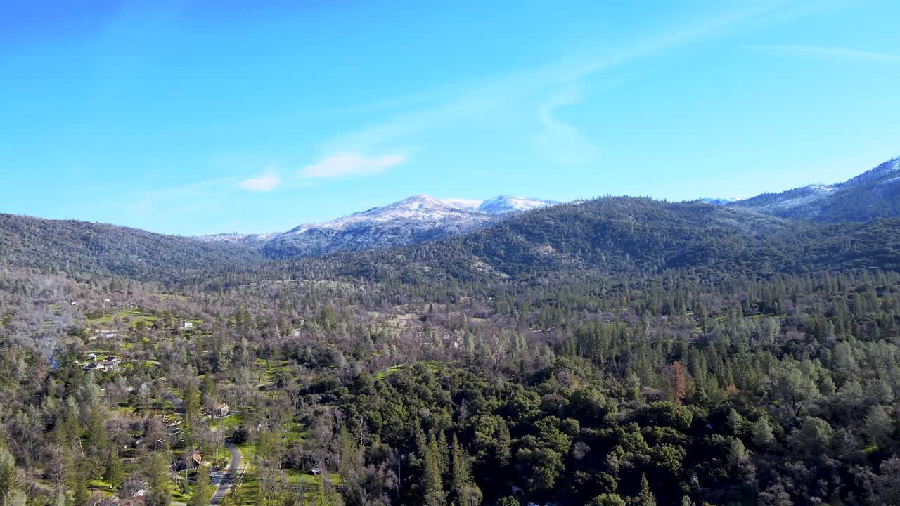 vista aérea del parque nacional de yosemite, bosques verdes exuberantes, colinas onduladas, montañas cubiertas de nieve, cielo azul claro, paisaje sereno, amantes de la naturaleza, aventura, estados unidos
