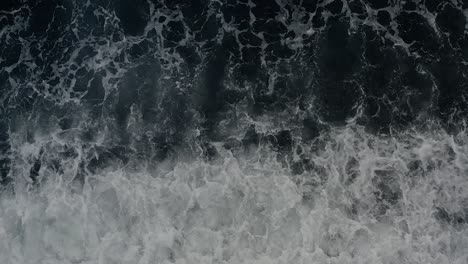 top view of dark blue ocean waves raging over a coastal beach in the philippines