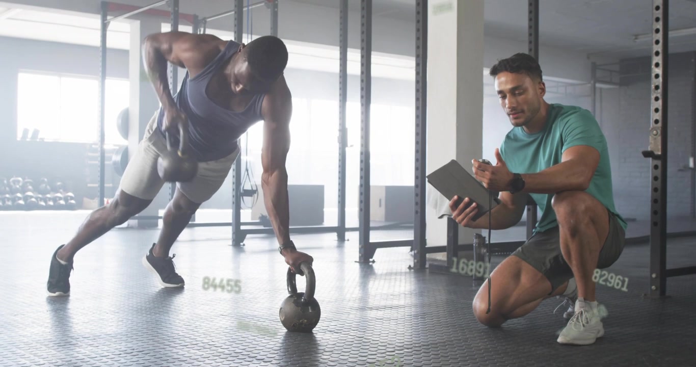 Gym trainer tapping tablet starting client doing kettlebell rows with animated timer counting reps