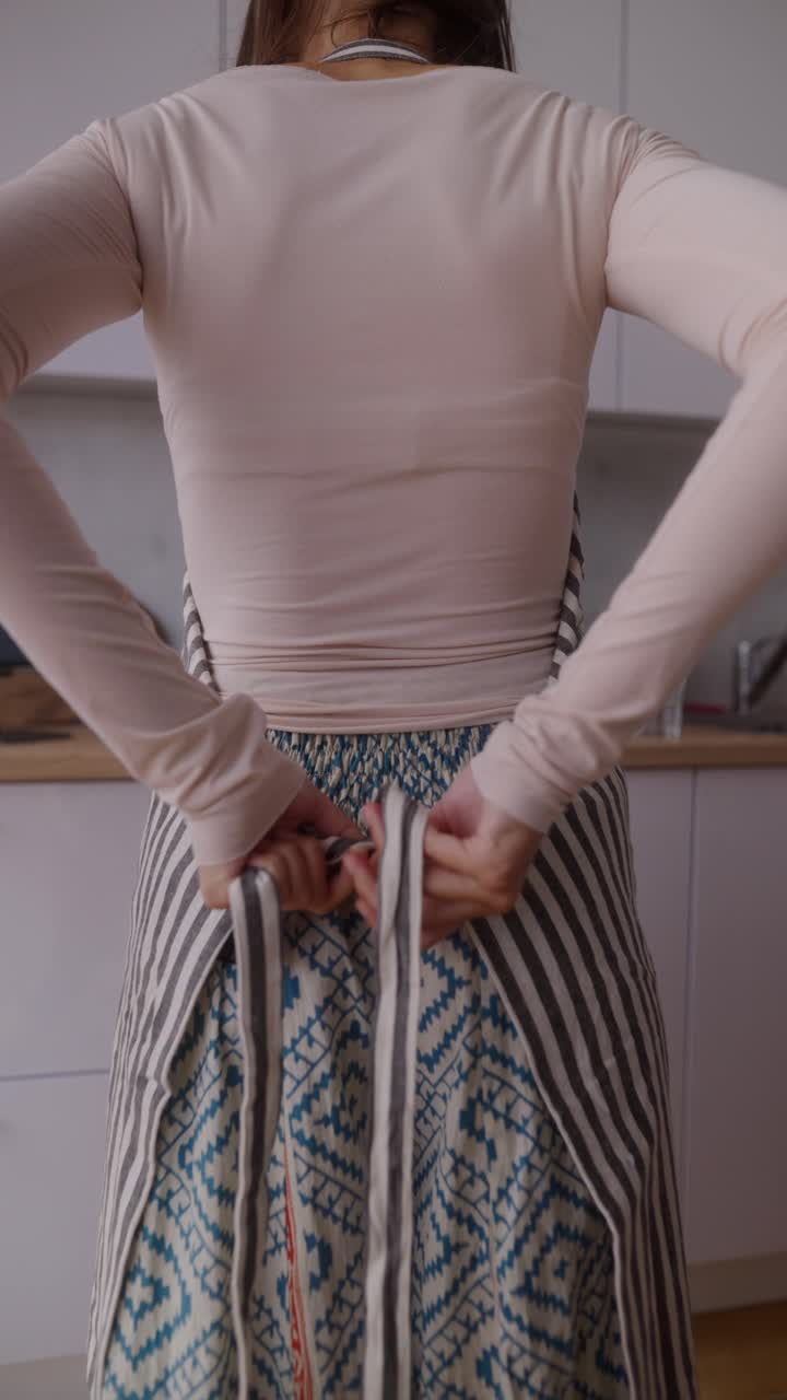 Woman Tying an Apron in the Kitchen