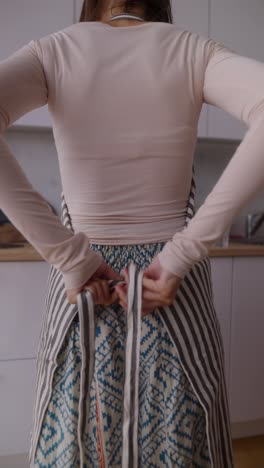 woman tying an apron in the kitchen