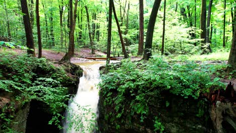 A-cinematic-view-of-Cascade-falls-among-leaves-and-moss-covered-boulders-in-Nelson-Ledges-State-Park-on-a-beautiful-Autumn-day