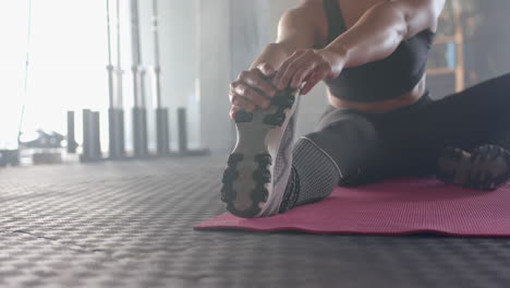 stretching on yoga mat, strong fit woman in gym touching toes for fitness workout, copy space