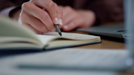 Businesswoman hands editing diary tasks on notebook at workplace