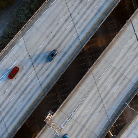cars go by the multi-lane road on the freeways to both sides. top view on the speedways above water.