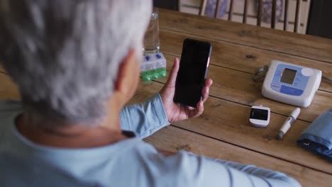 mujer de raza mixta senior que tiene una consulta médica en línea usando un teléfono inteligente