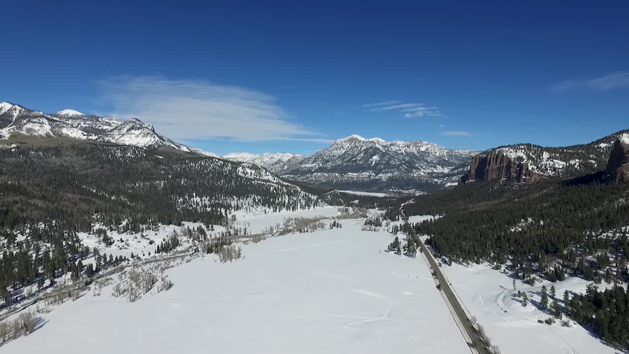 도로 옆 눈 덮인 산을 향해 날아가는 드론 공중