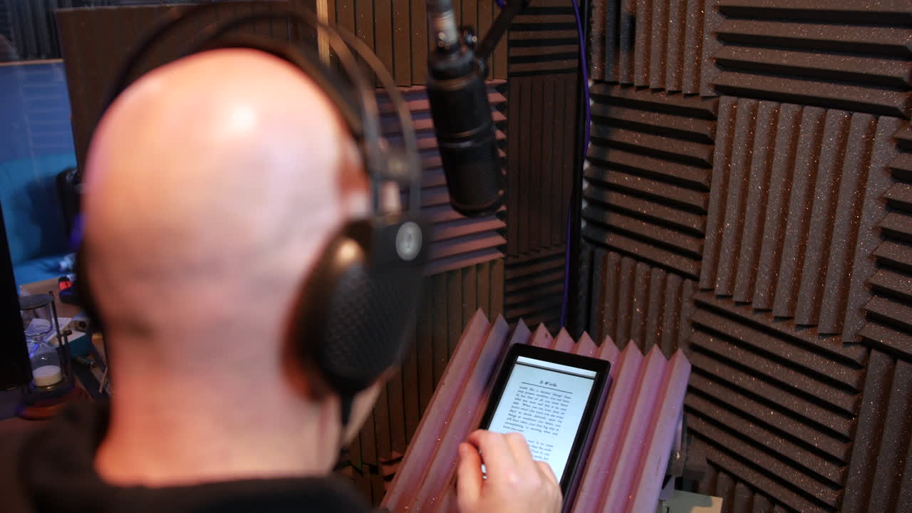 un hombre grabando y podcast de audiolibros en una cabina de voz en off de un estudio de grabación