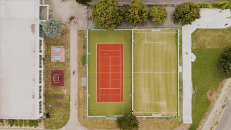 aerial descending top-down view of a multi-sport field, soccer field and a skate park