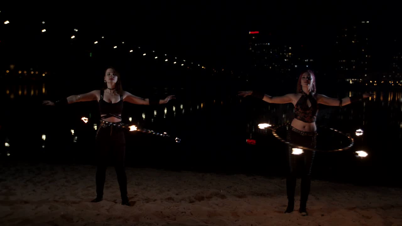 las hembras girando el fuego bonito hula hoops en la cintura