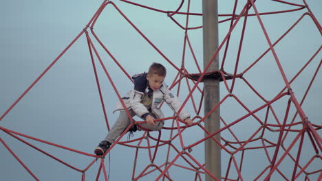 a boy on a red climbing web