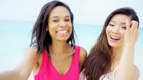 portrait of multi ethnic girlfriends on ocean sand