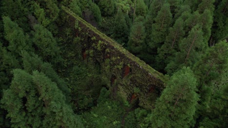 Top-angle-drone-shot-of-an-abandoned-aqueduct-in-São-Miguel-Island,-Portugal