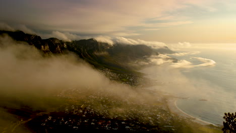 Strange-low-cloud-formations-over-mountains,-Camps-Bay-in-view,-Cape-Town-South-Africa