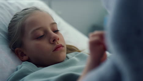 portrait upset kid hospital ward playing with plush toy. pediatric unit patient