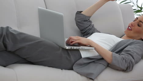 businesswoman working lying down on a sofa