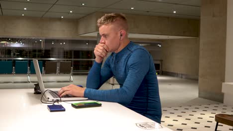 A-young-man-working-from-his-laptop-at-a-table-in-Changi-international-airport