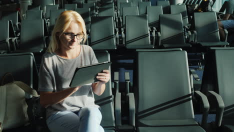 woman in airport gate uses tablet