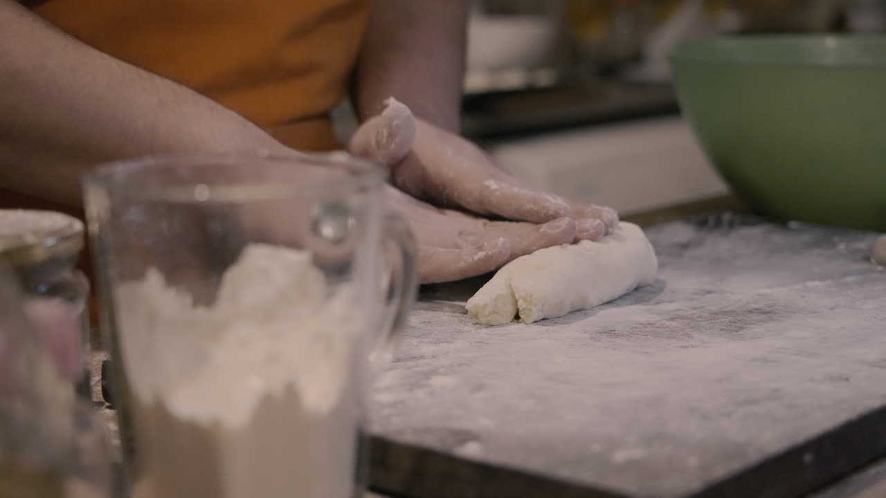 Close-Up of Hands Kneading Dough with Flour on a Wooden Board