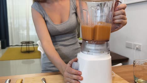 una mujer haciendo un batido.