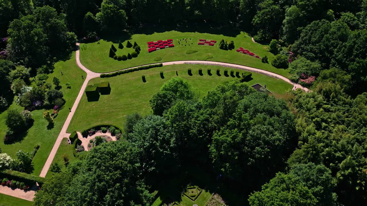 Upside drone view of large landscaped Upper Brittany Botanical Park with winding paths and flower beds, Le Chatellier, France.