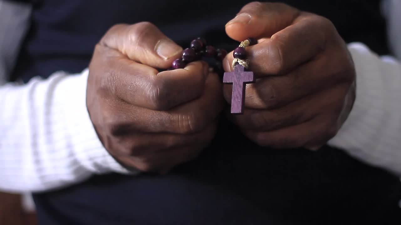 orando a dios con la cruz en las manos juntos