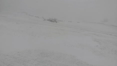 flying a drone over a log home in a thick snowstorm