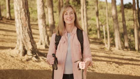 active senior woman looking at camera in forest