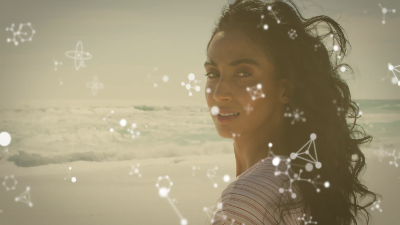 On beach, woman with molecular structure animation overlaying her view