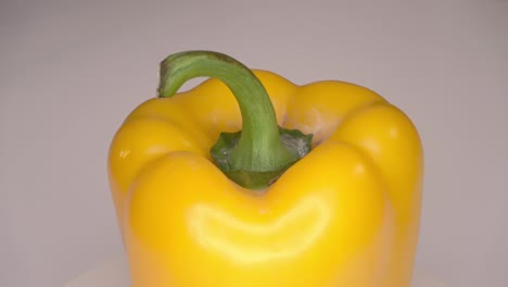 loopable 4k footage of a single bell pepper spinning against a white background.