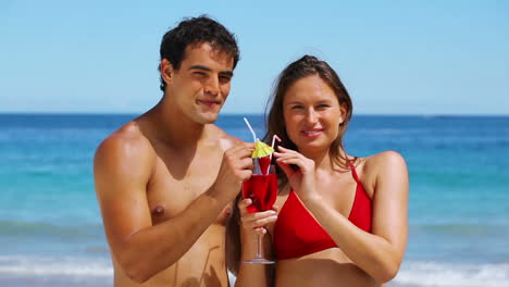 una pareja bebiendo un cóctel.