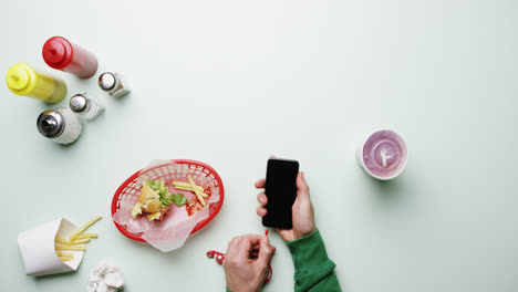 top view man connecting headphones to mobile phone at american diner fast food restaurant hands from above - red epic dragon