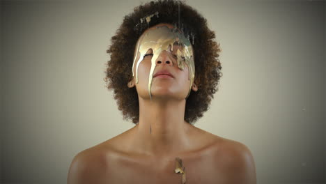 woman with gold paint dripping on face