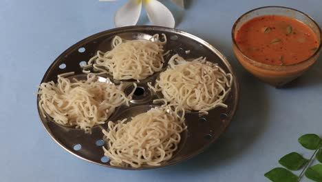 Noolappam-Idiyappam-rice-noodles,-popular-traditional-steam-cooked-Kerala-breakfast-dish-with-hot-and-spicy-chickpea-lentil-curry-on-banana-leaf,-Alappuzha,-India