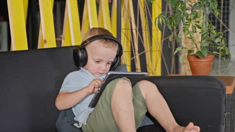 boy with headphones listening to music on tablet