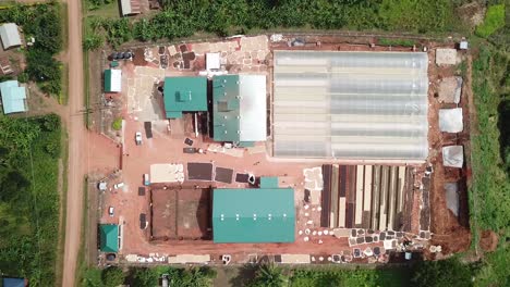 Aerial-top-down-of-coffee-beans-processing-factory-in-rural-Uganda,-Rwenzori-Mountains