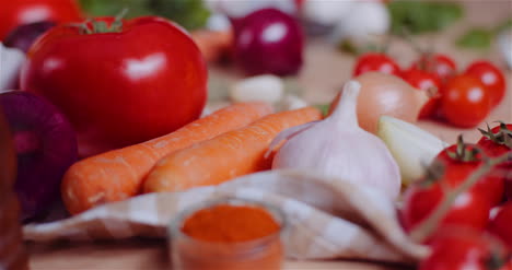 Close-Up-Of-Various-Vegetables-On-Table-Rotating-Fresh-Tomato-Carrot-Red-Onion-And-Garlic-